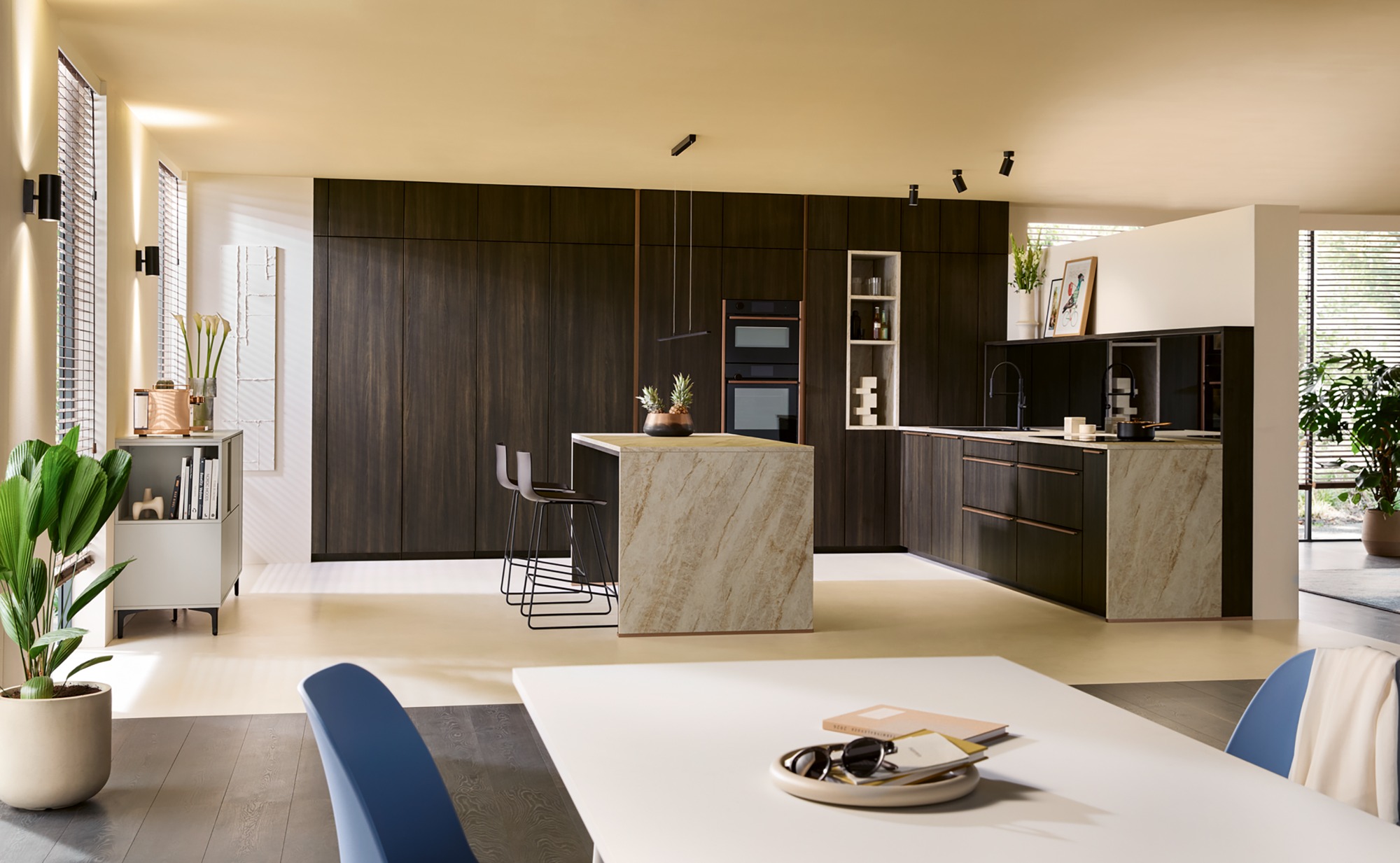 Moderne Küche mit Holzdetails, Insel und Essbereich. Helle, offene Gestaltung.